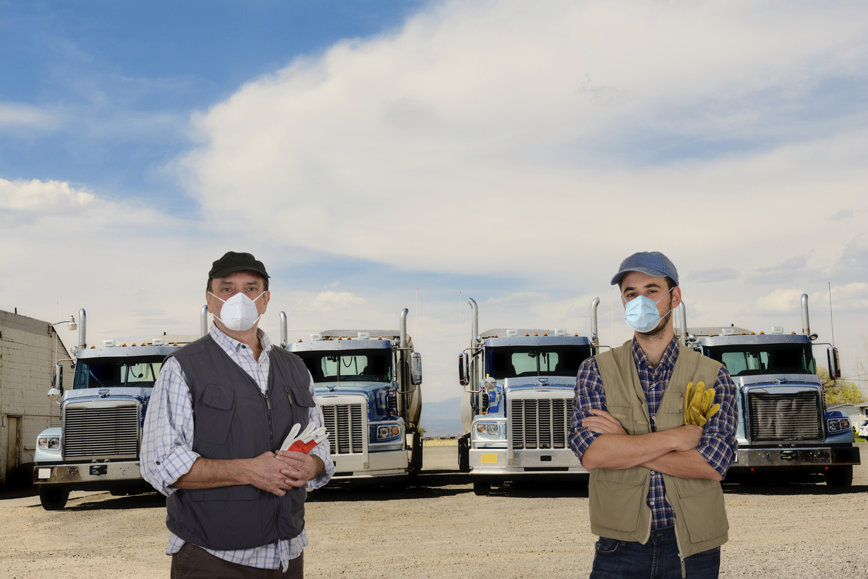 Mature and young truck drivers with protective masks and gloves during the COVID-19 pandemic