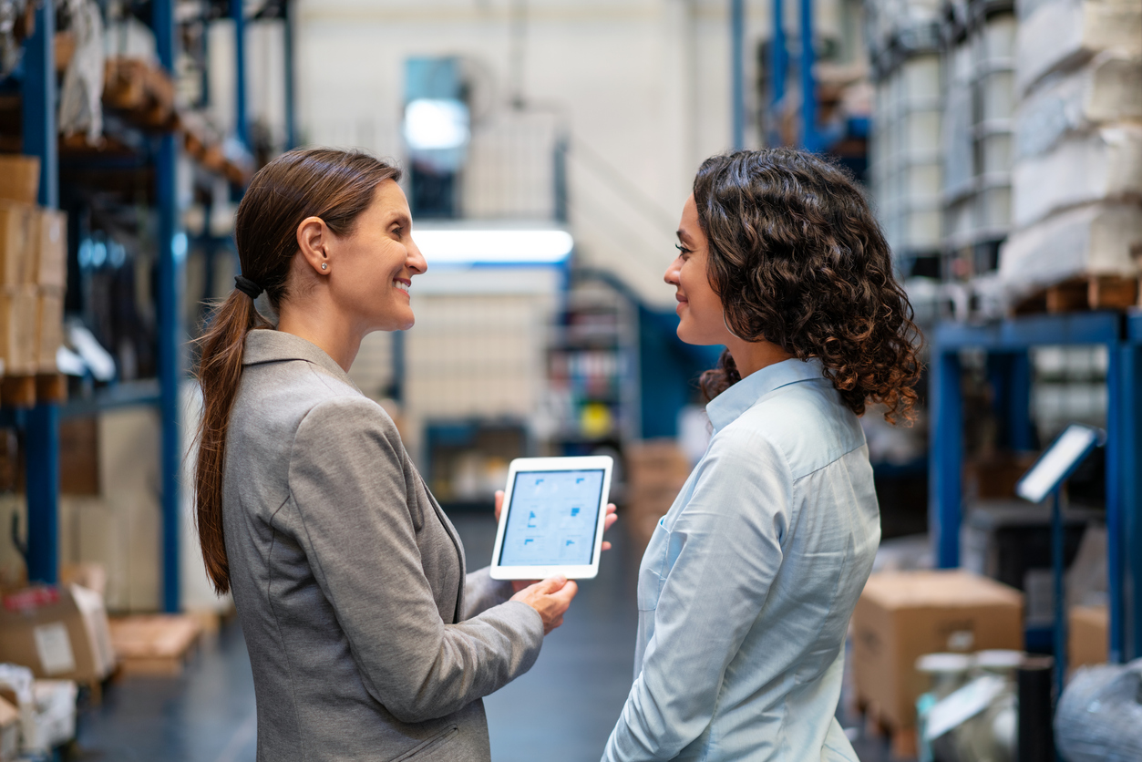 Warehouse manager showing an app on tablet to supervisor